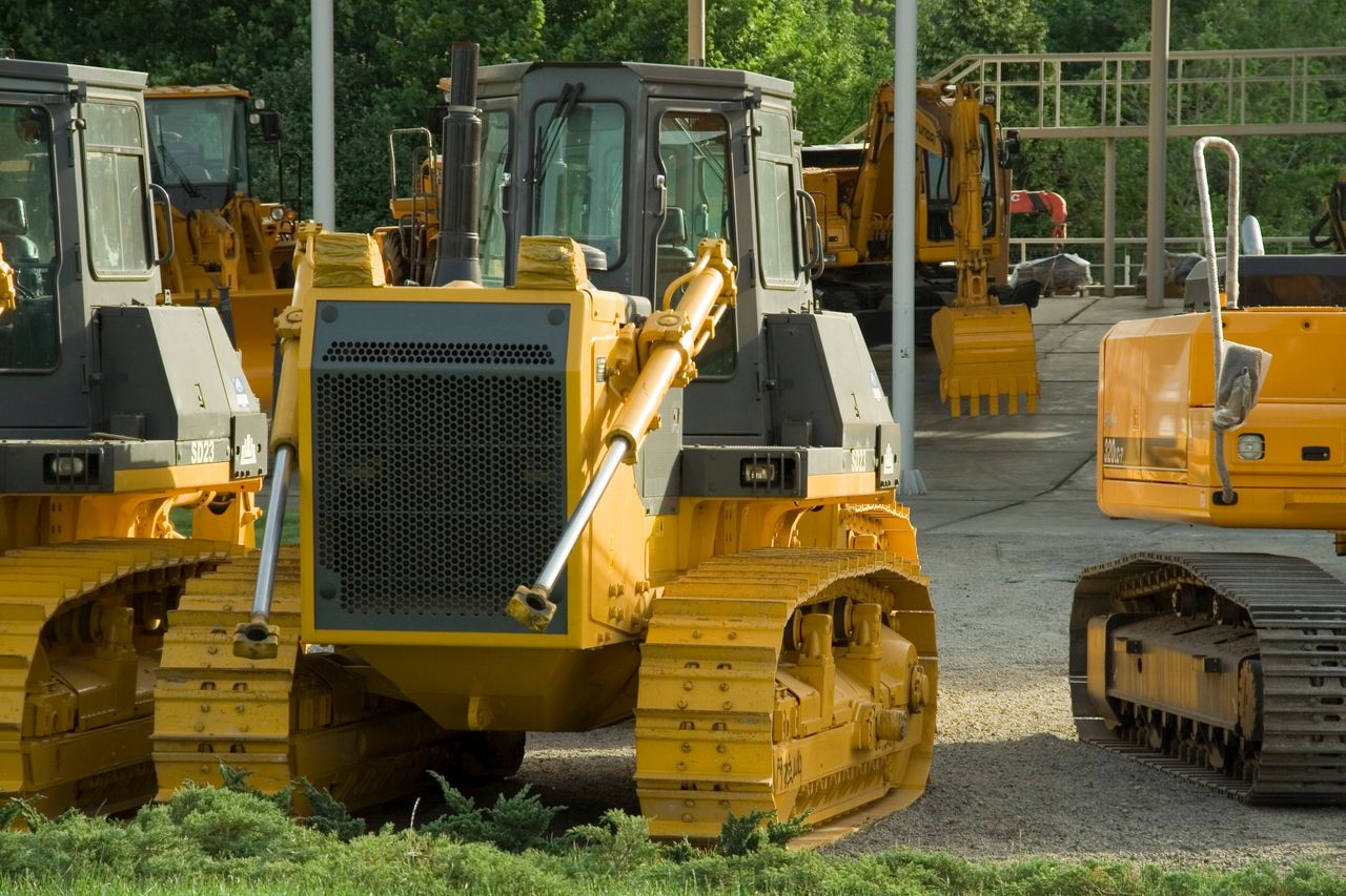 Multiple bulldozers parked in an outdoor construction area, ready for use.