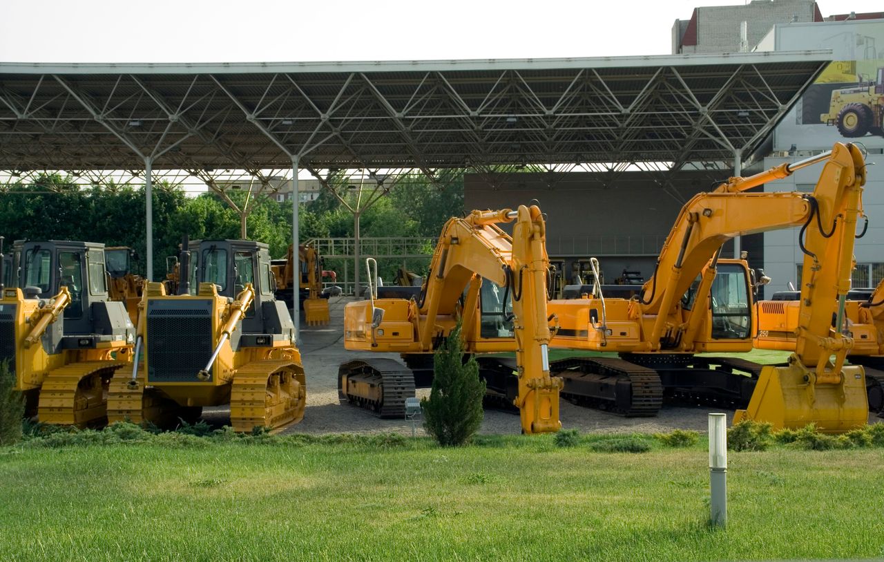 Heavy-duty construction machinery displayed outdoors, include excavators and bulldozers.